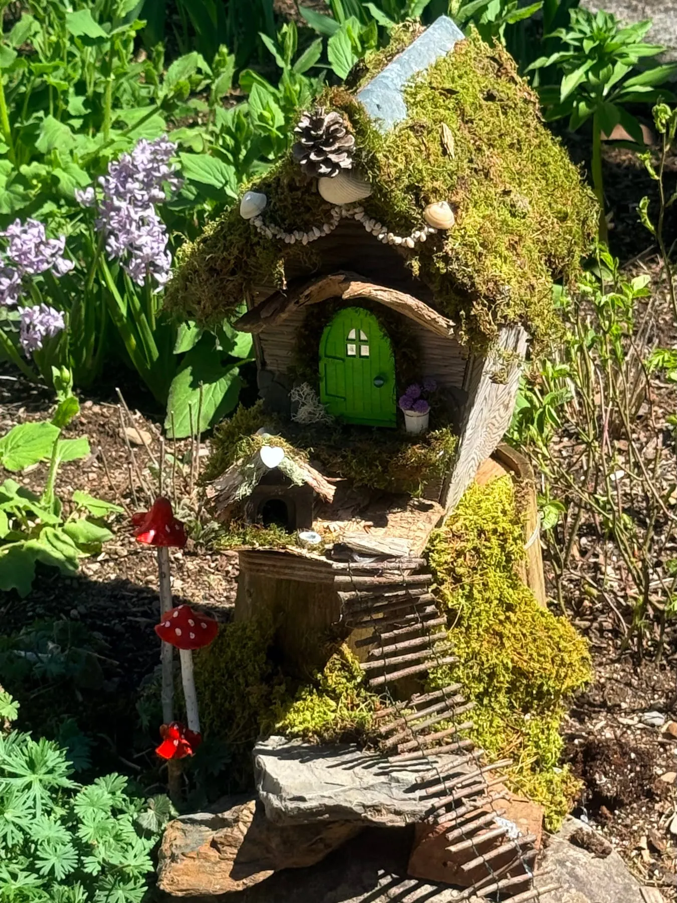 A freshly finished faerie cottage with its round green door open in welcome.